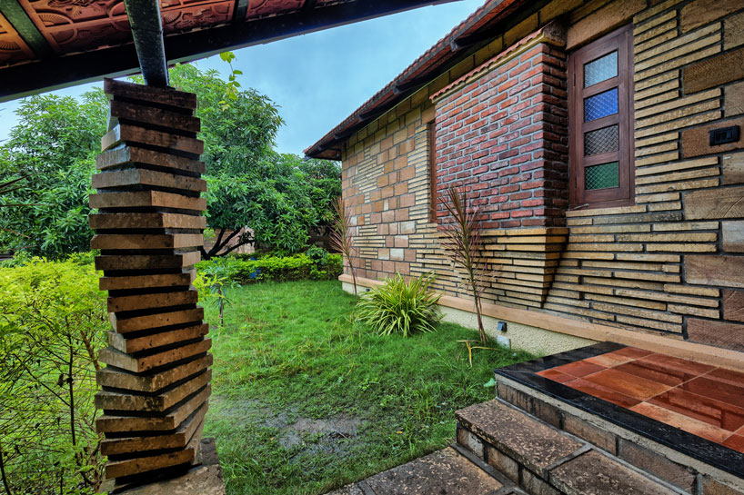 Inbuilt sit out at foyer along with twisted sand stone column below roof adds drama into the welcoming gesture.