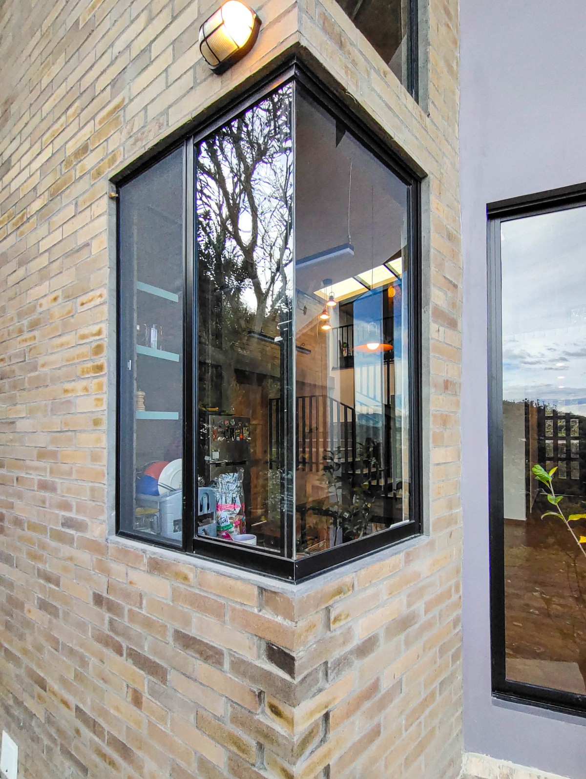 Corner kitchen window, embraced by the exposed brick walls around it