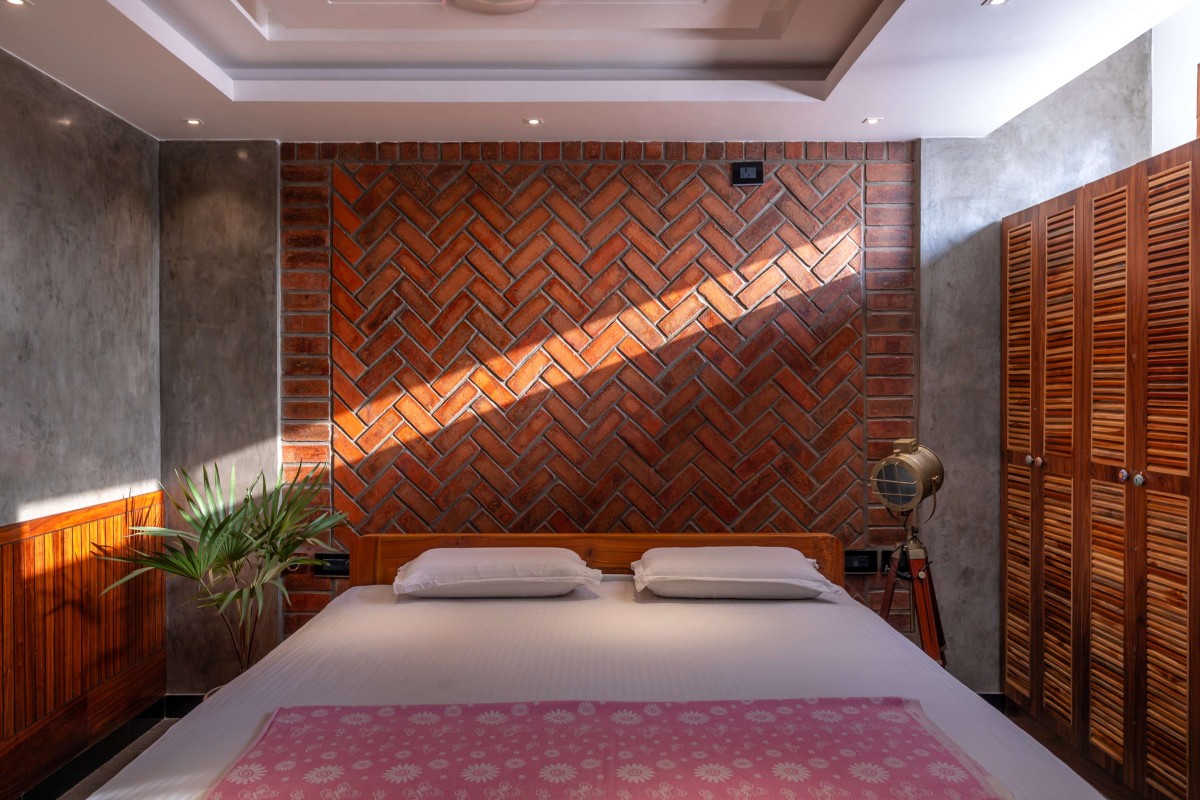 Master Bedroom with a Ribbon window finished with Grey Oxide in contrast to exposed wire-cut brick feature wall - Kuteeram by Brick and Compass