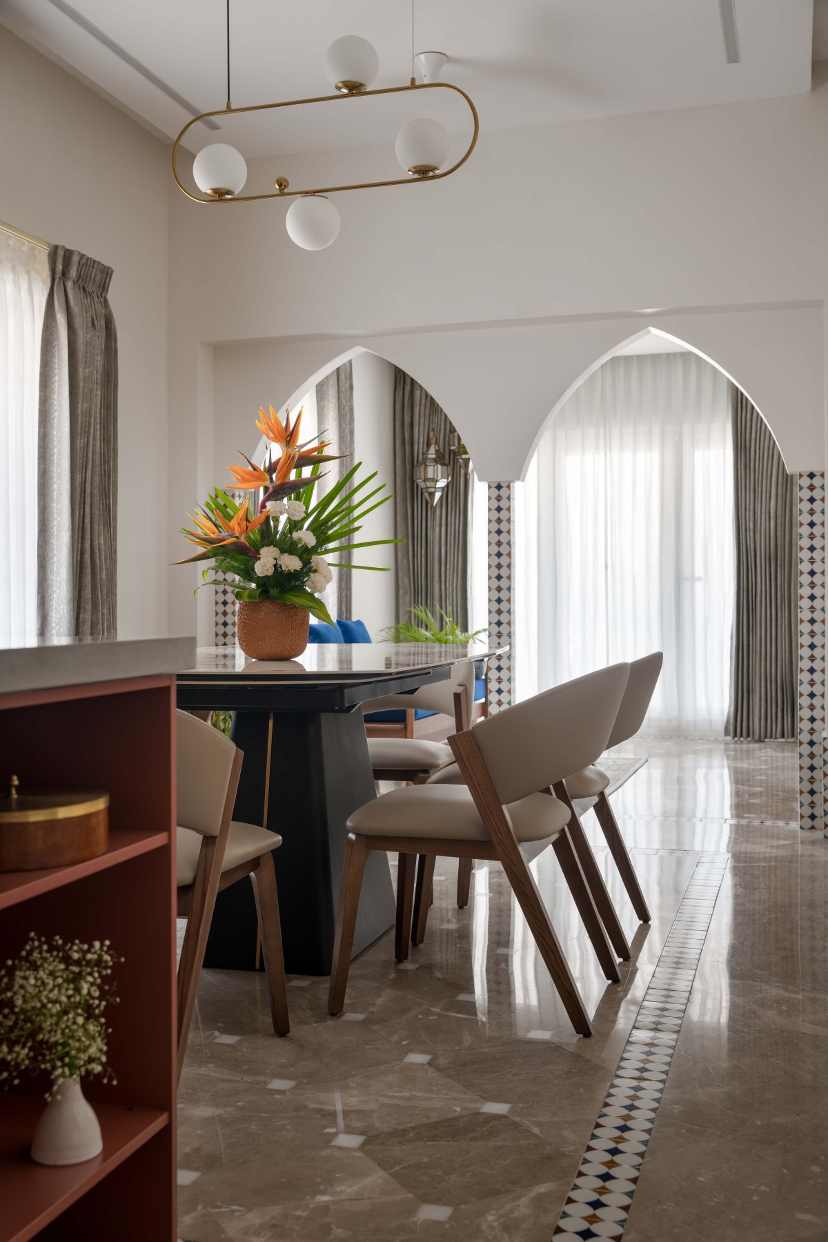 The foyer, dining room, and an open kitchen, delineated by arches and distinct flooring patterns