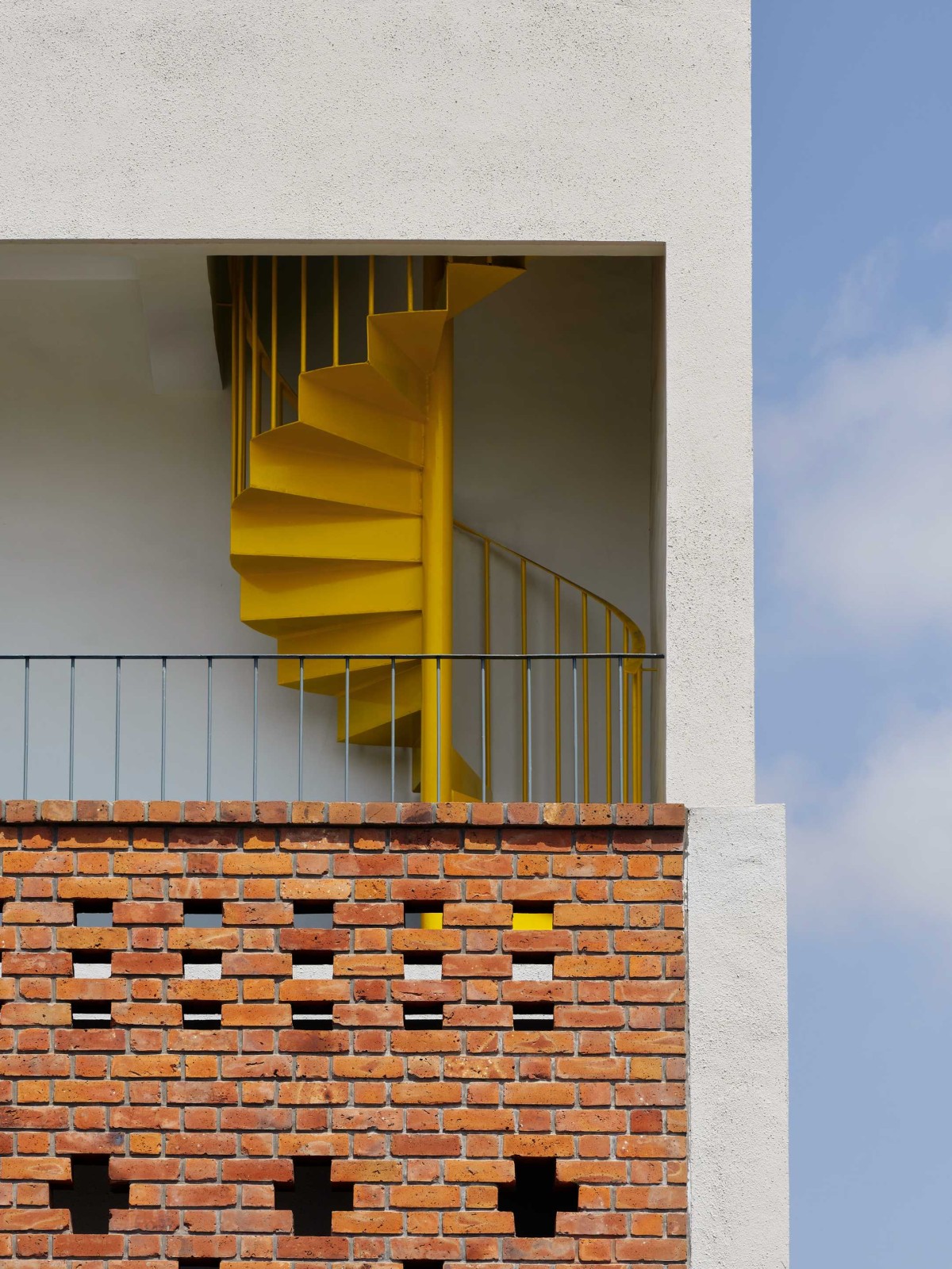 Yellow Spiral Staircase of Within Cuboids by Alok Kothari Architects