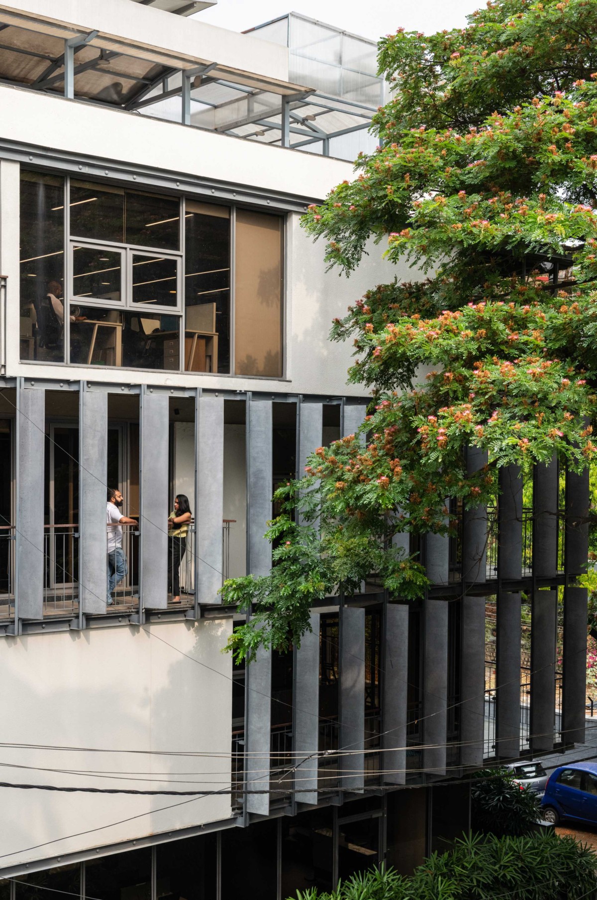 Rhythmic façade complimented by the existing rain trees of Slate house by Funktion design