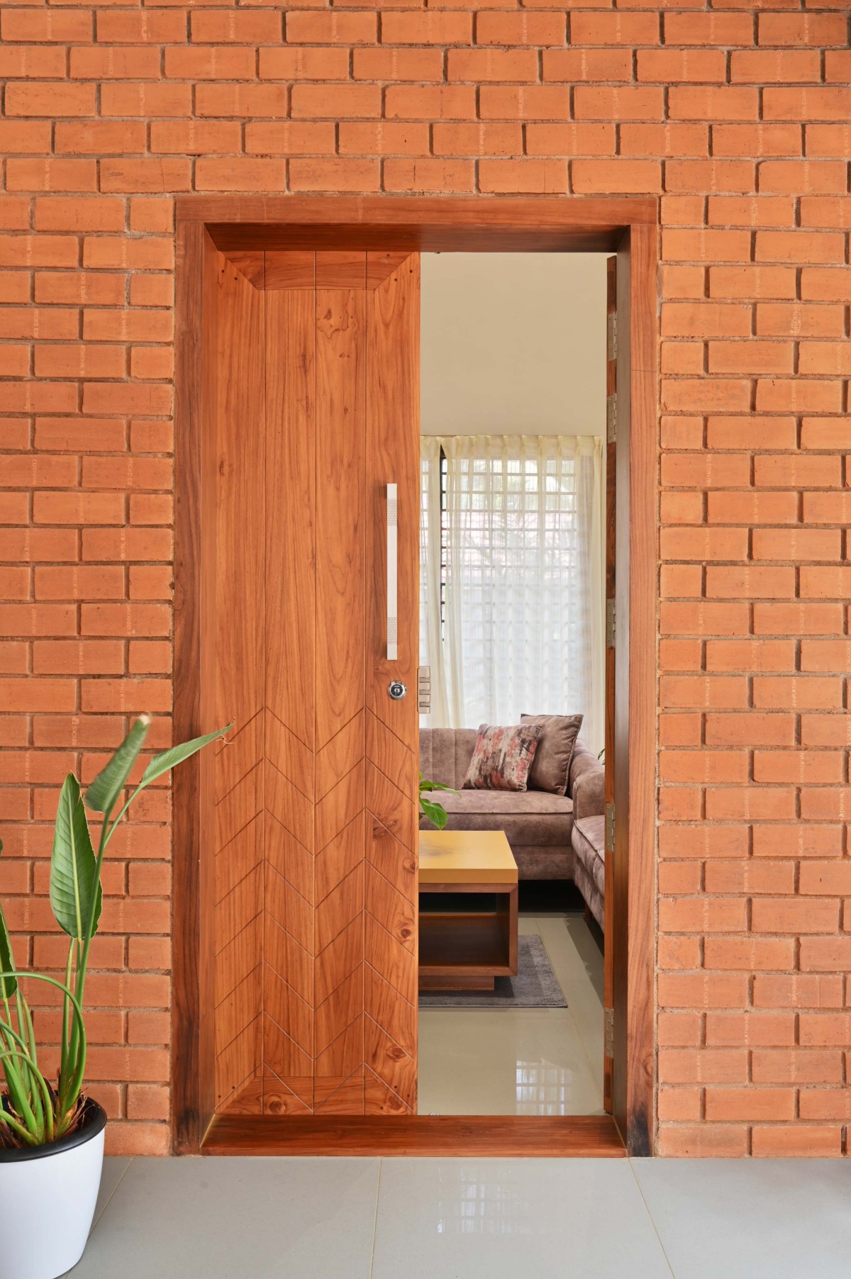 Entry to living room of Brick Screen House by HONEYCOMB Architects