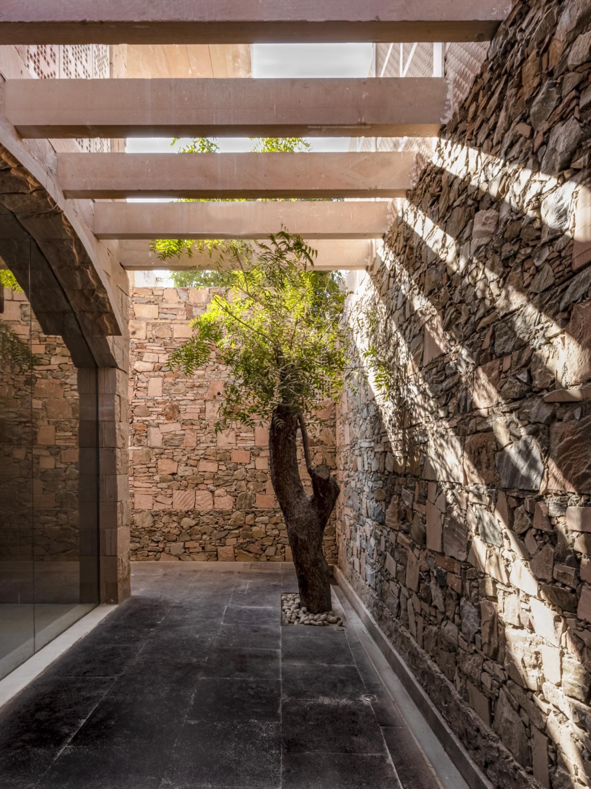 Outdoor lobby of Stone House by Malik Architecture