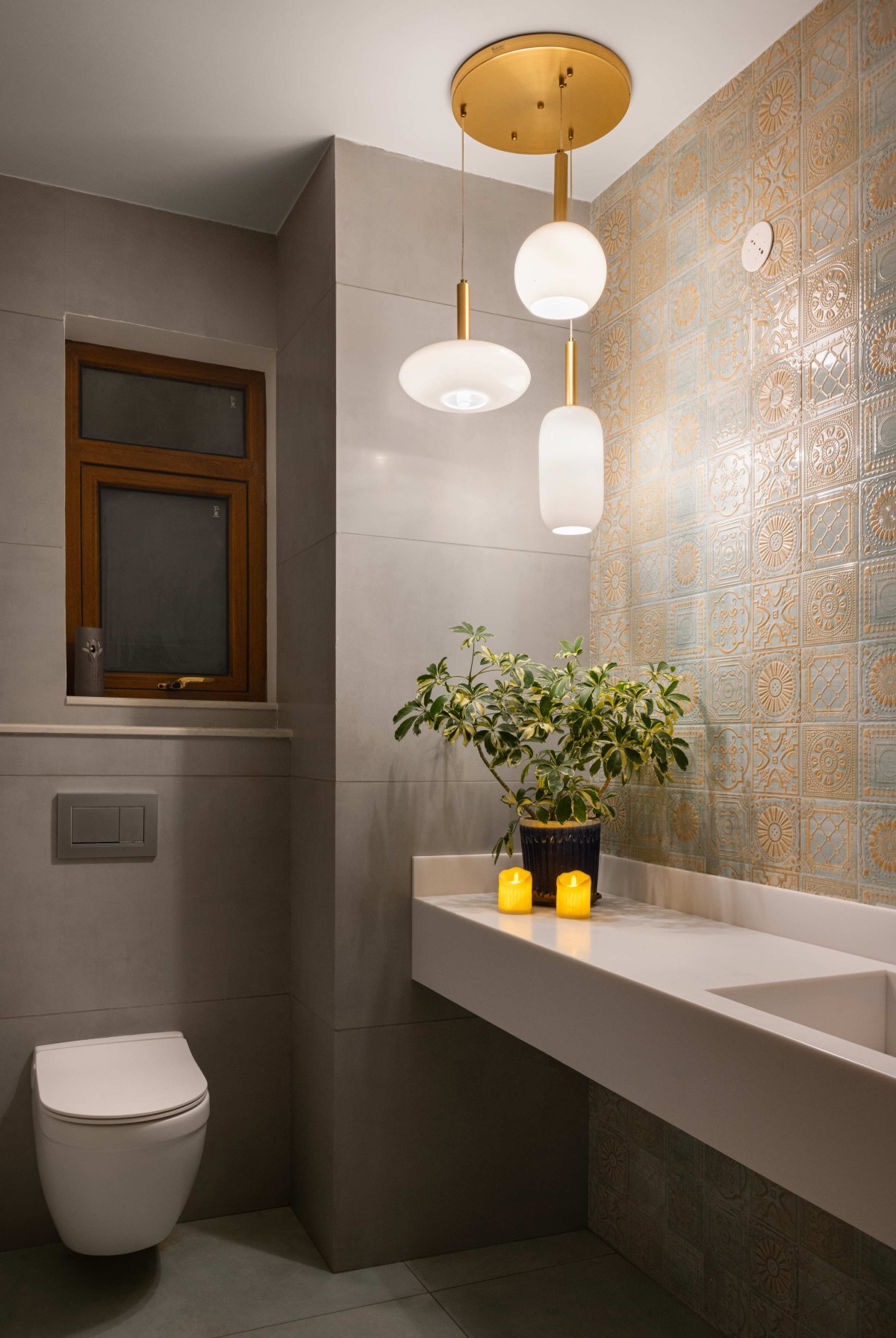 Powder room is enlivened by grey tiles paired with Moroccan-inspired design ceramic tiles and a daisy white washbasin countertop