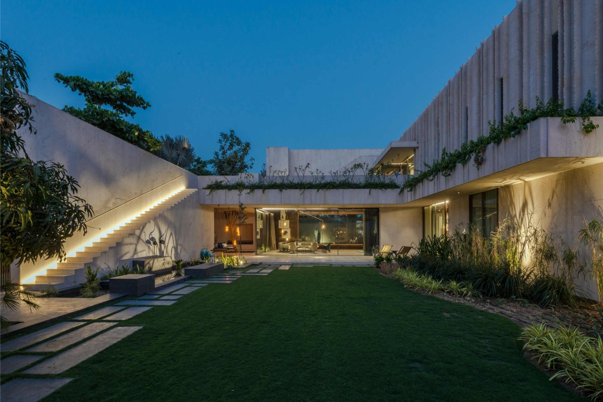 Dusk light view of lawn of The House Of Secret Gardens by SPASM Design Architects