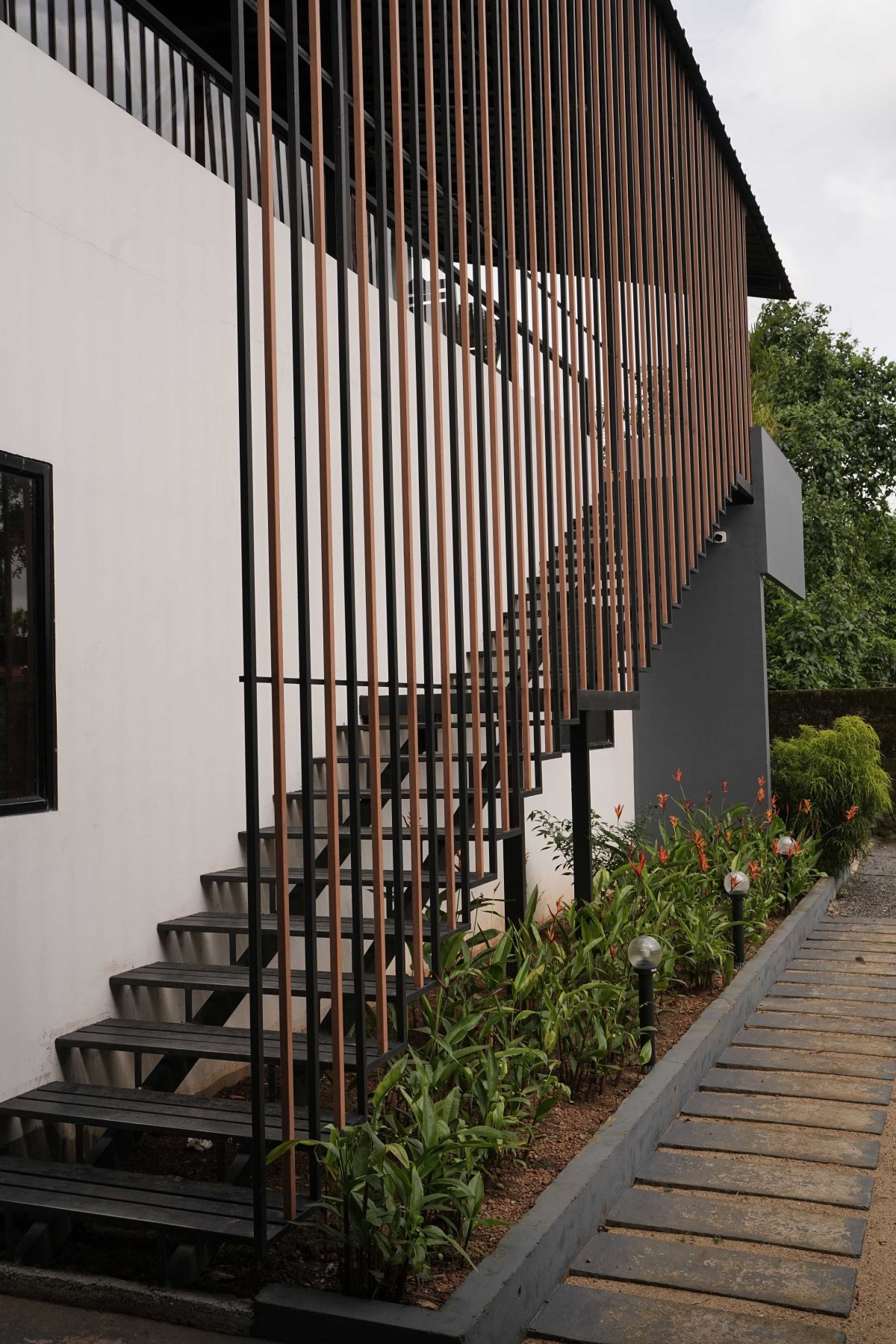 Staircase to covered dining area of Manjal - The Portico by Lykke Architecture Studio