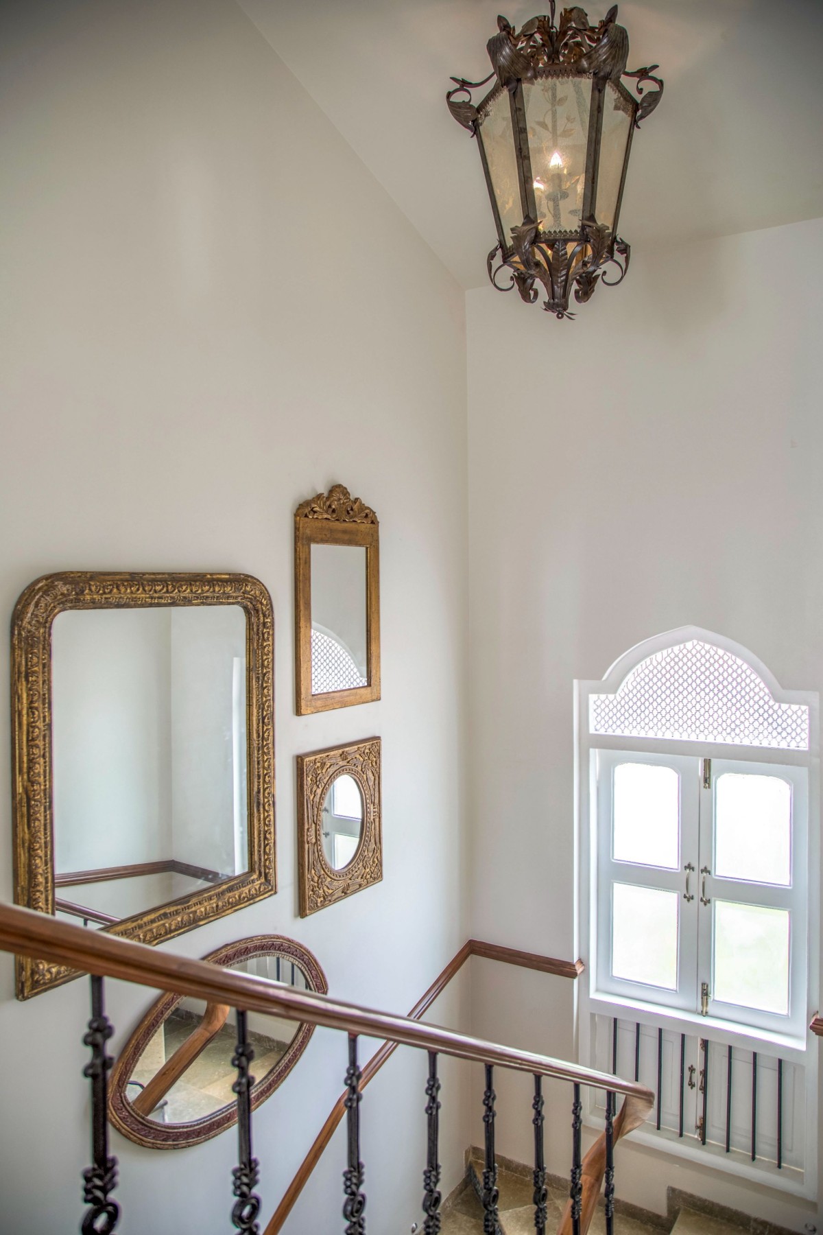 . The staircase also has a big chandelier, adding more character and depth to the space.